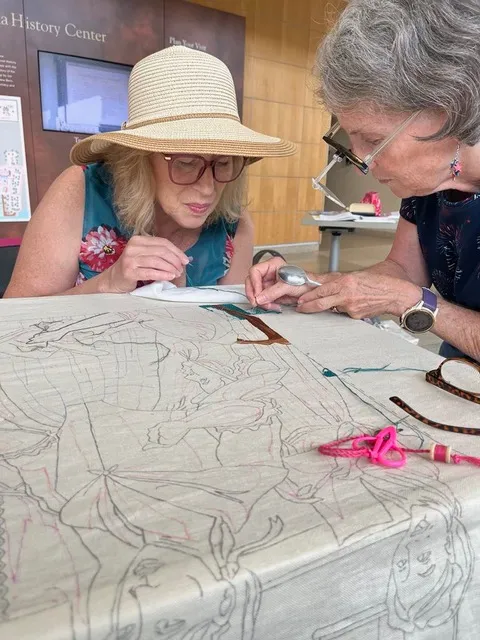 Gail Smith and Kim Meyers Robertson stitching on the North Carolina panel