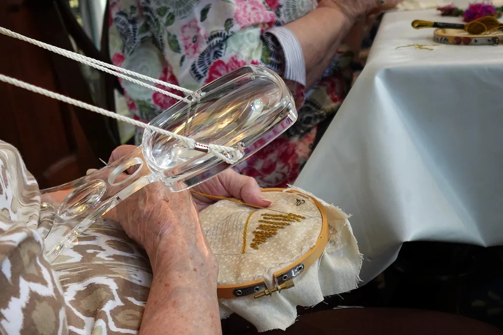 Volunteer Nancy Cook works on a palm frond slip for the panel's palmetto tree