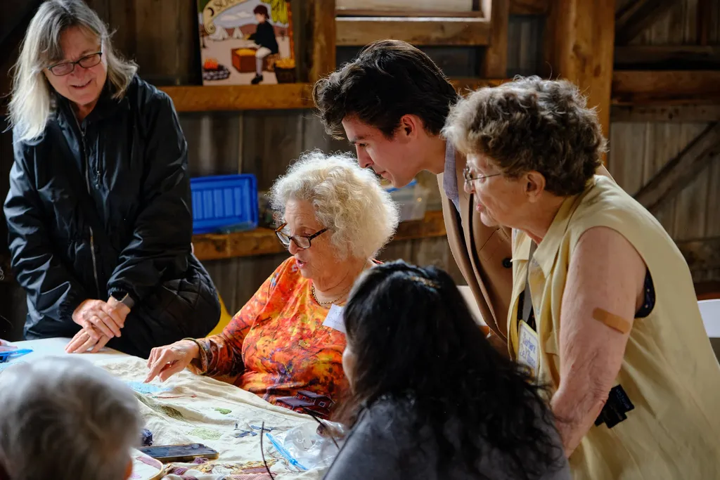 Chapter President and tapestry volunteer Patti Tidemann showcases the gorgeous sky on the New Jersey panel