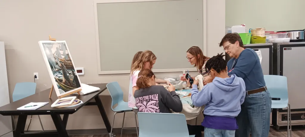 Girl Scout Troop 286 work on the Delaware panel with the help of co-director Becky Gutin