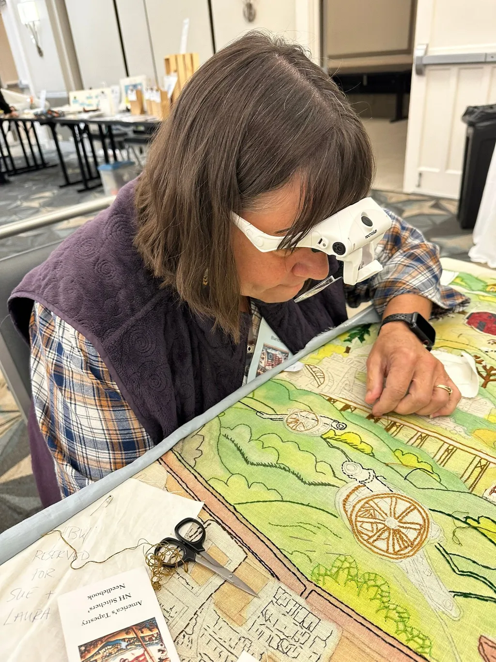 NH volunteer Vicki Brown embroiders on the Connecticut panel