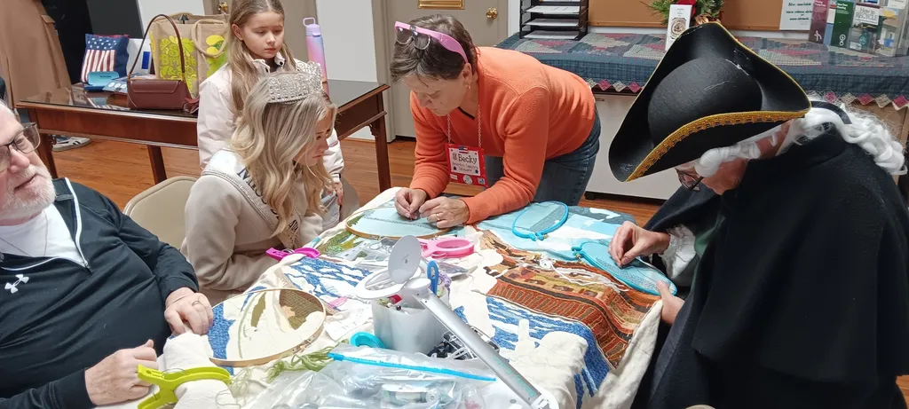 Christmas in Odessa attendees stitch on the Delaware panel with the help of co-director Becky Gutin